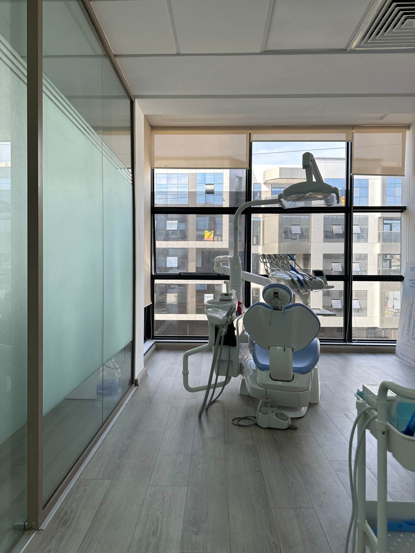 Salle de soins dentaires lumineuse équipée d'un fauteuil et d'un scialytique